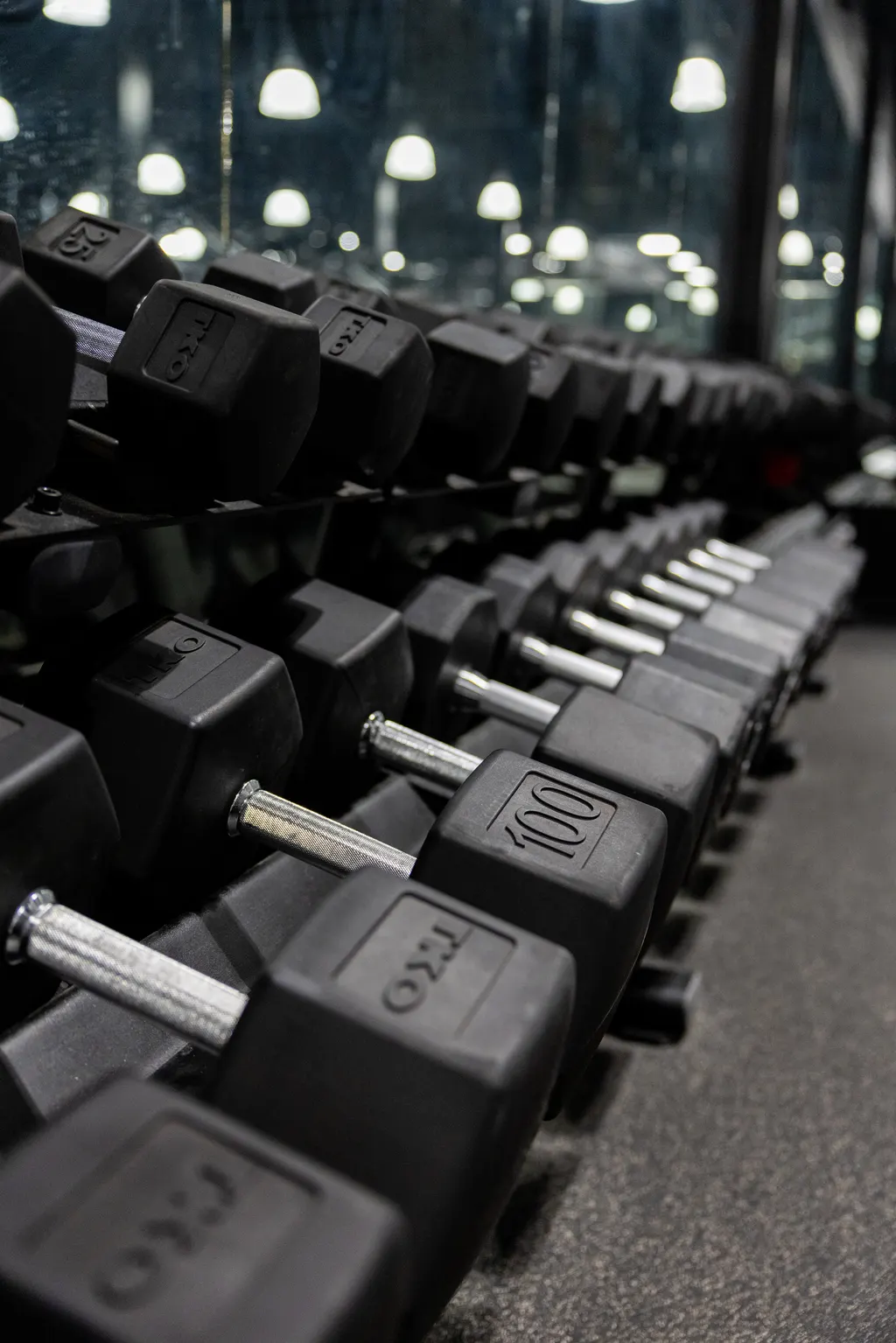 Rows of dumbbells racked on the DPS strength floor