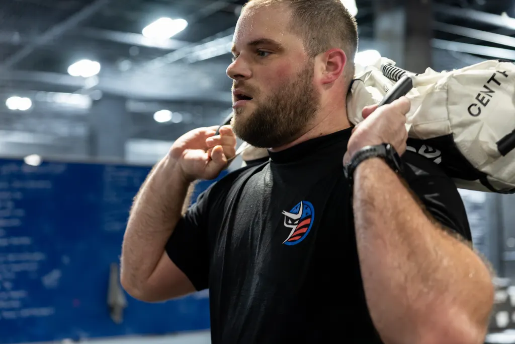 Athlete carrying a HYROX sandbag across the shoulders at DPS