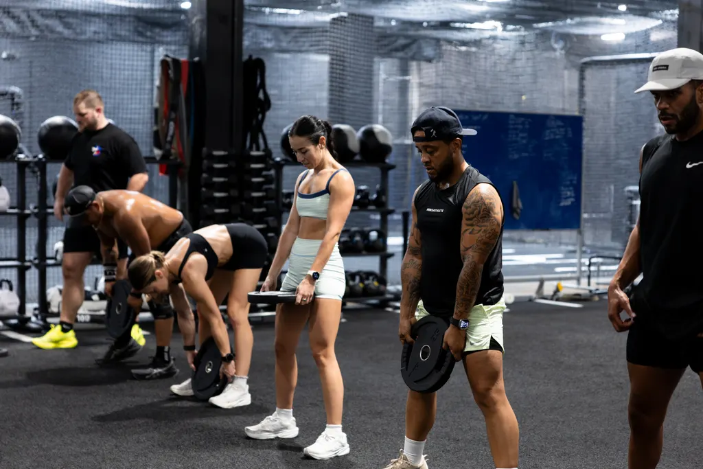 Coached strength class training with plates on the DPS workout floor