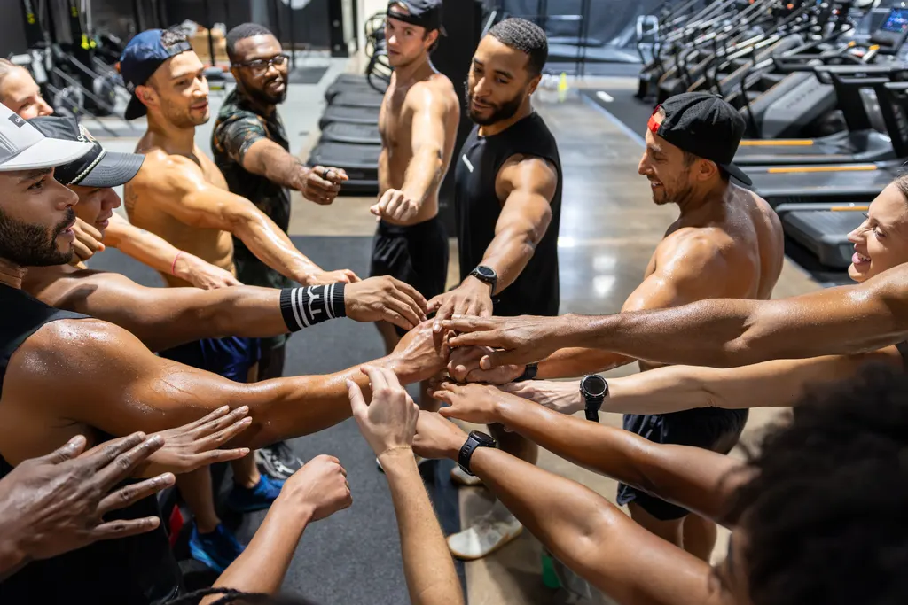 Members stacking hands in a huddle after class at DPS